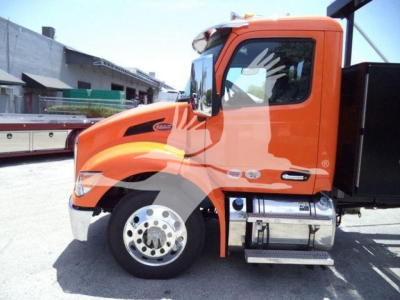 Peterbilt 536 truck cab in orange, side view showing front wheel, mirrors, and fuel tanks.