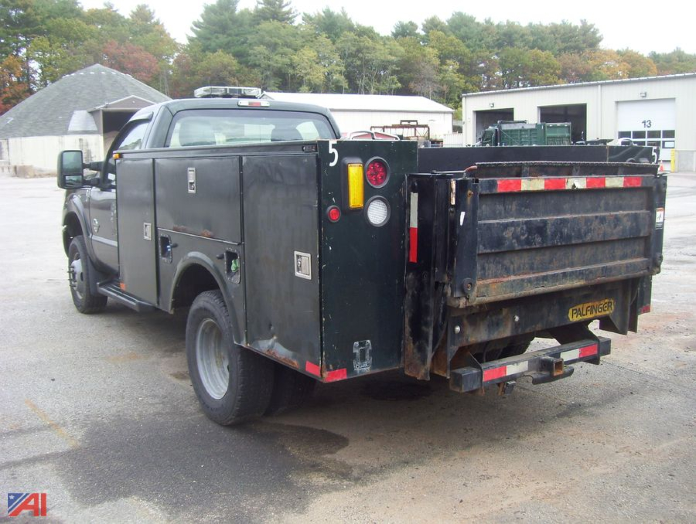 Ford F-350 Super Duty service utility bed rear view showing dual rear wheels and toolbox compartments with rusted dump bed.