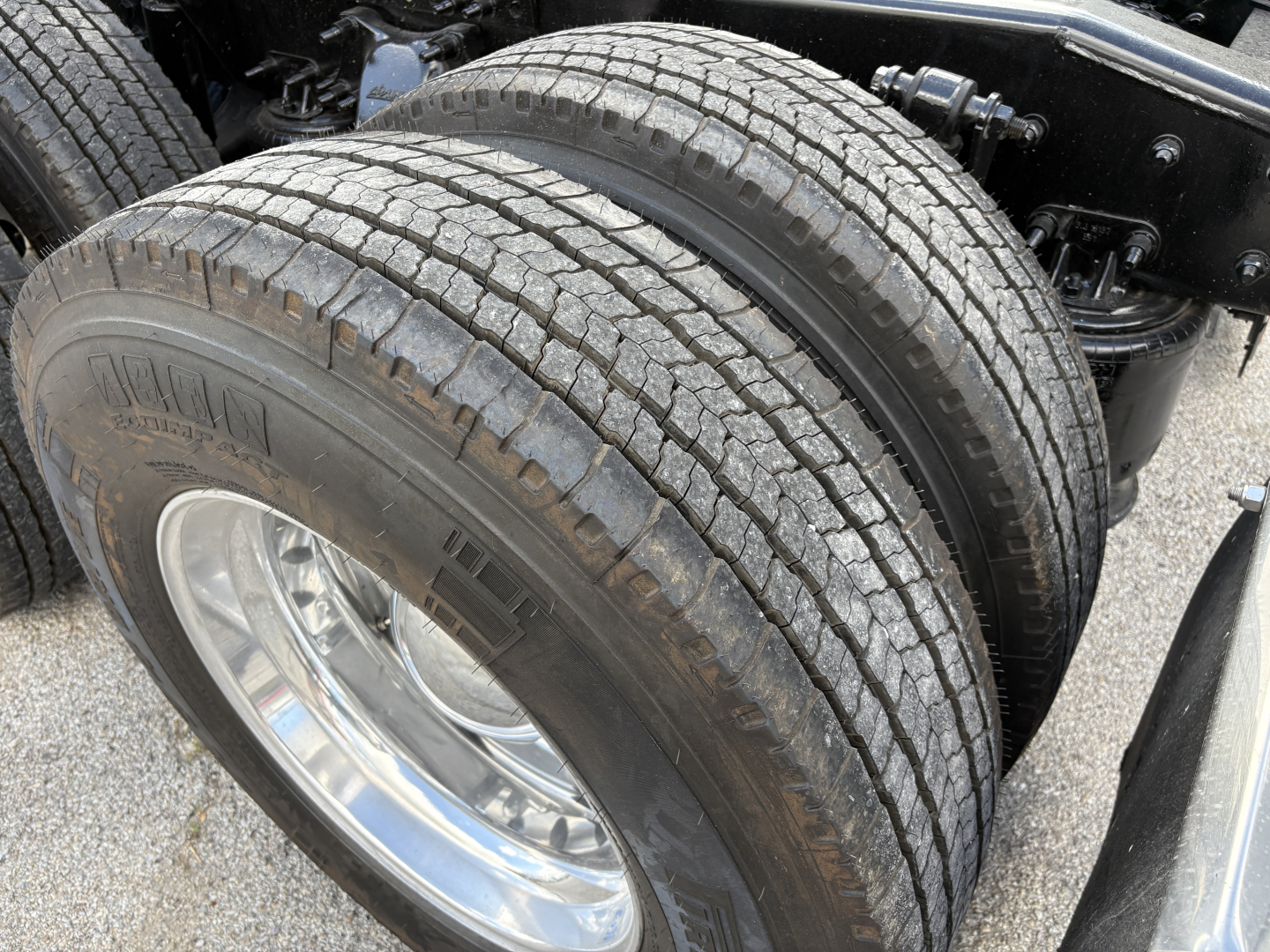 Freightliner Cascadia 126 axle with dual rear tires and chrome wheel, part of a used truck in view.