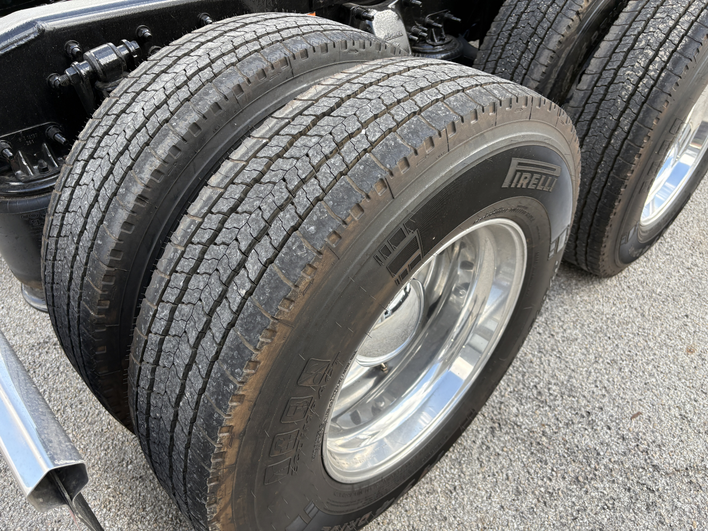 Truck wheel and dual-tire assembly showing Pirelli tire brand and tread, part of Freightliner Cascadia 126 chassis.