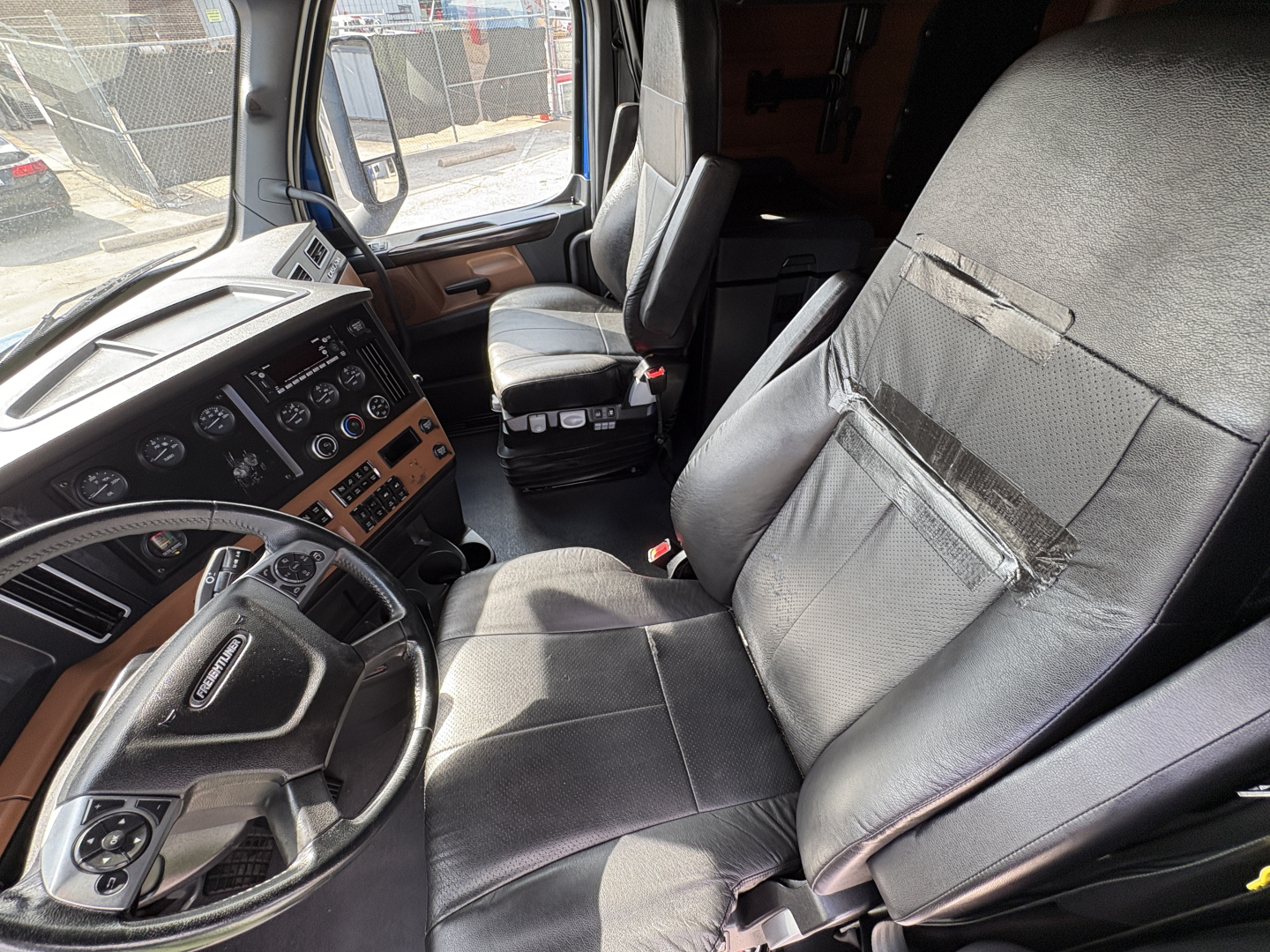 Freightliner Cascadia 126 truck interior driver and passenger seats with dashboard controls visible.