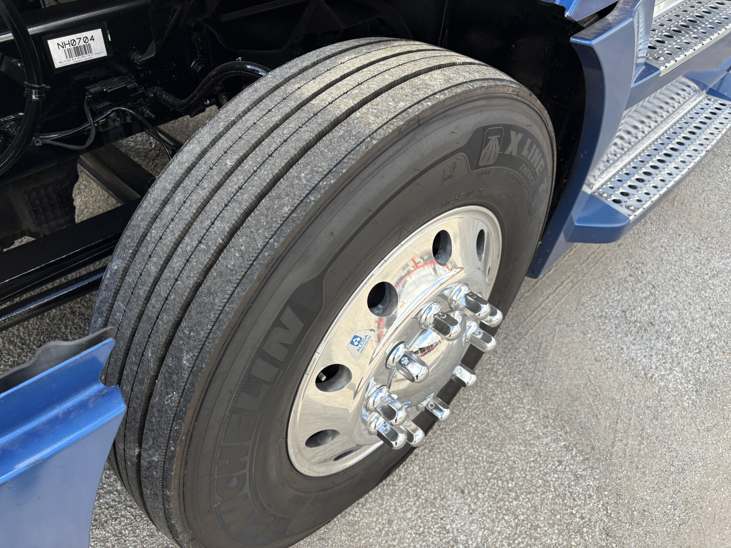 Freightliner Cascadia 126 wheel and tire close-up view showing dual rear axle front wheel with polished aluminum rim and lug nuts.