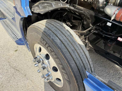 Front drive axle and dual tires of a Freightliner Cascadia 126 with Michelin tire branding and wheel studs visible