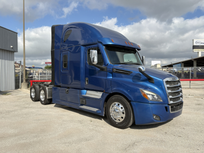 Freightliner Cascadia 126 sleeper tractor in blue, side view showing chrome wheels and extended cab with dual rear axles.