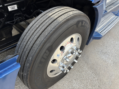 Freightliner Cascadia 126 wheel and tire close-up view showing dual rear axle front wheel with polished aluminum rim and lug nuts.