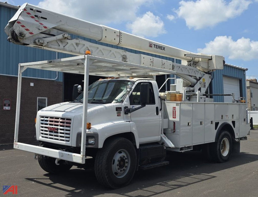 GMC TopKick C7500 utility truck with mounted Terex bucket lift, white service body, extended bucket boom, front grille, cargo compartments, and stabilizing outriggers in view.