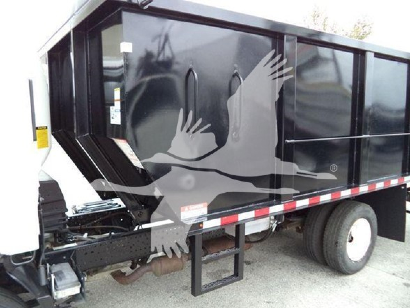 Isuzu NPR dump truck side view showing cargo bed and wheel