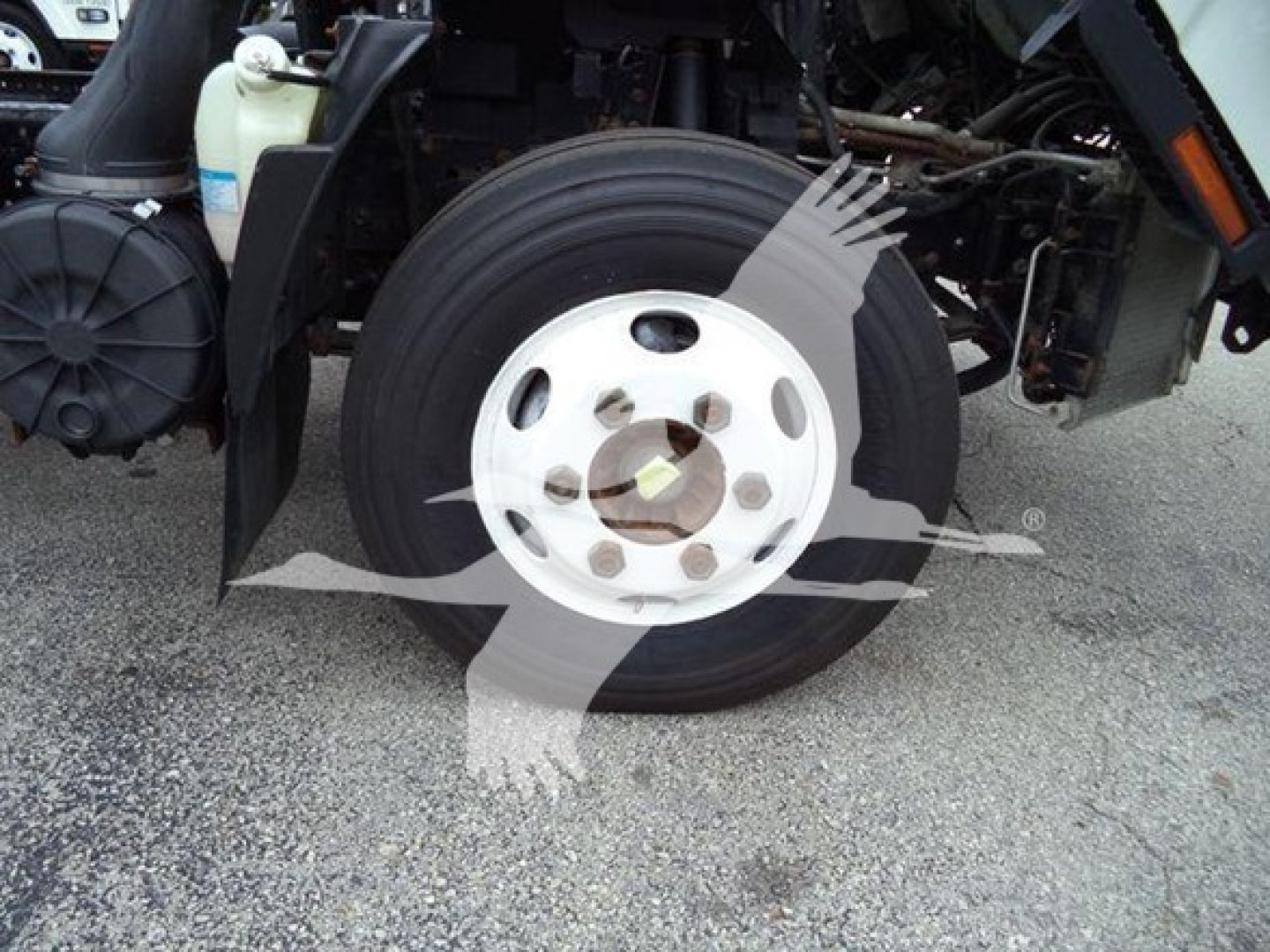 Isuzu NPR front wheel and suspension view with wheel hub, tire, and surrounding truck components visible