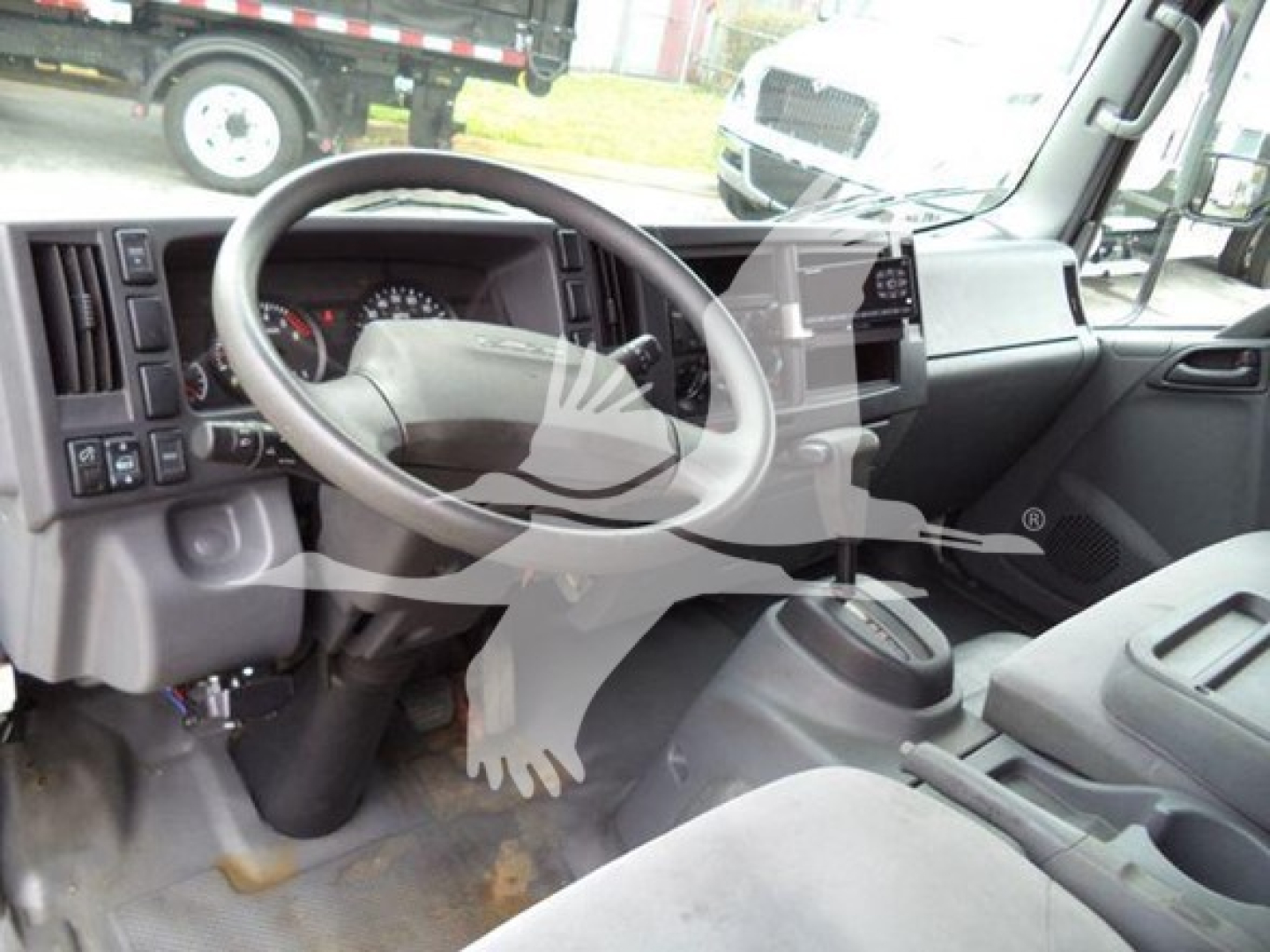 Isuzu NPR cab interior showing steering wheel and dashboard view.