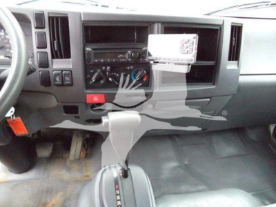 Isuzu NPR dashboard and gear shifter view showing climate controls, radio area, and center console.