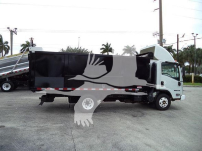 Isuzu NPR dump truck side view showing dumped cargo bed and cab in white and gray with palm trees in background.