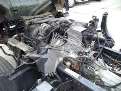 Isuzu NPR engine bay showing V-driving components and wiring harnesses.
