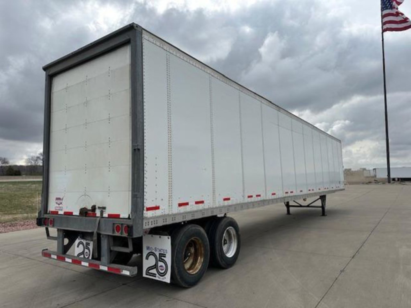 Trailer side-view of a 2016 Wabash box van trailer, white exterior, dual rear axles, freight trailer in an open lot.
