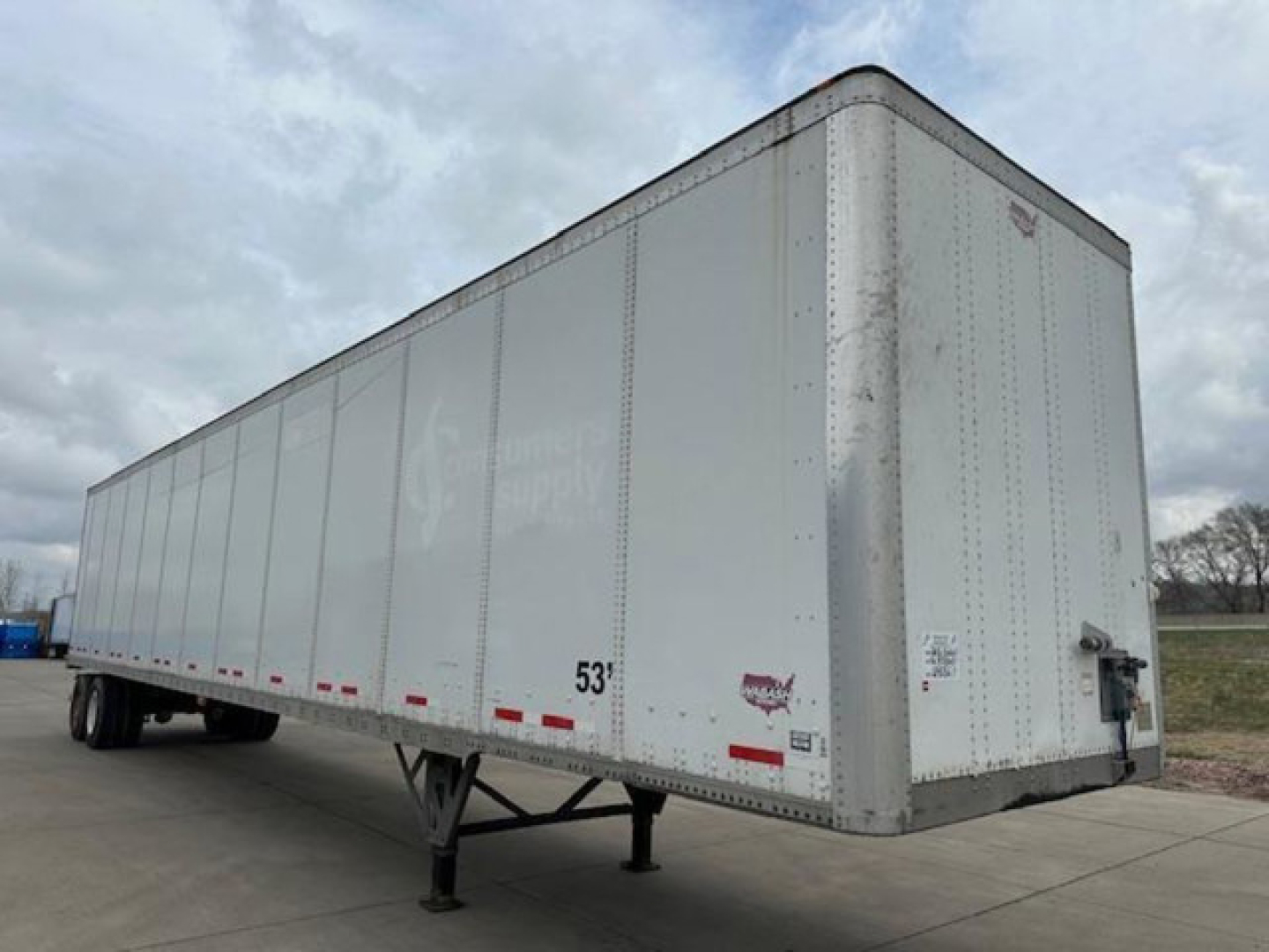 White 53' Wabash trailer with side rails and landing gear, front nose, DOT markings, and rear doors visible.