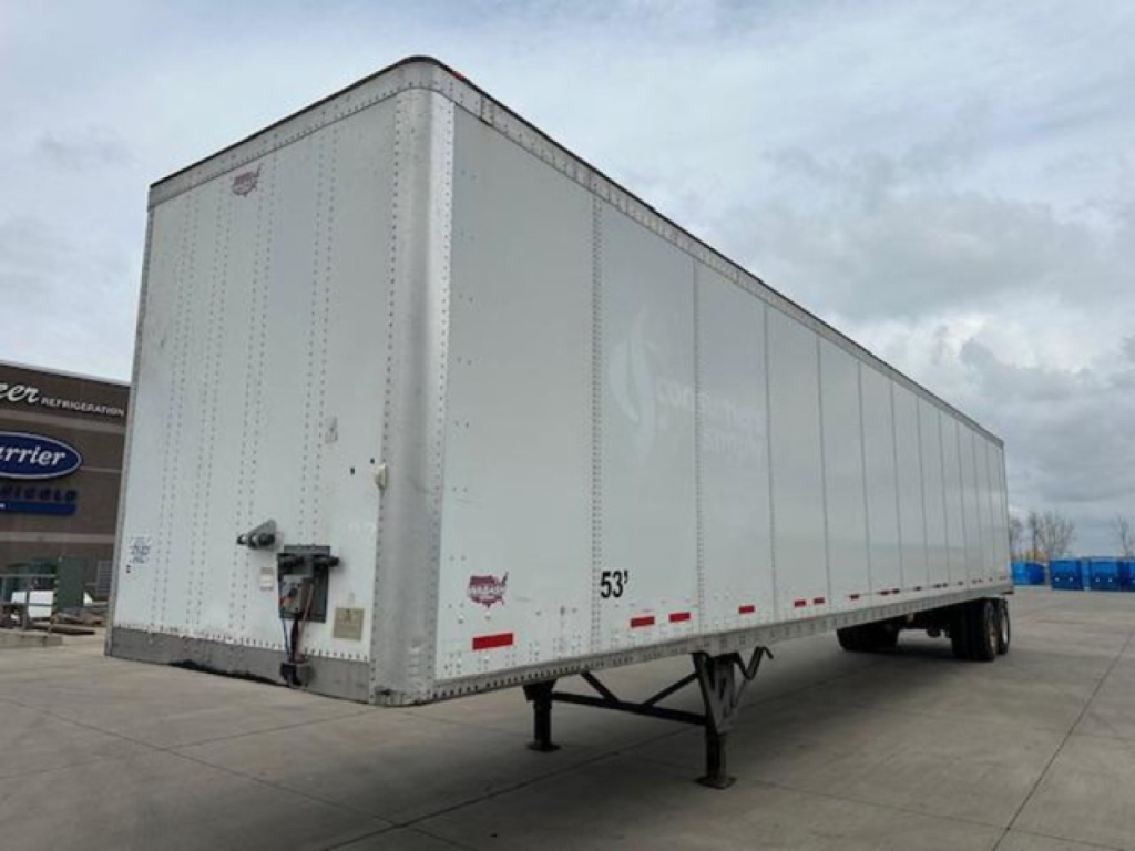 Trailer side view showing a white Wabash van trailer with a 53' length, undercarriage with landing gear and wheels, rear doors, and various small labels.