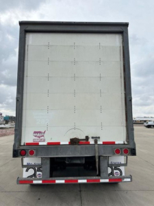 Trailer rear view of a 2016 Wabash van showing rear doors and bumper with taillights and plate area.