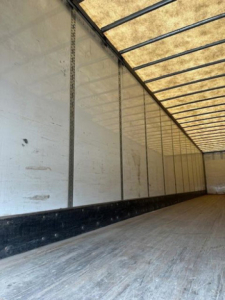 Trailer interior showing metal side walls and wooden floor of a used 2016 Wabash van trailer.