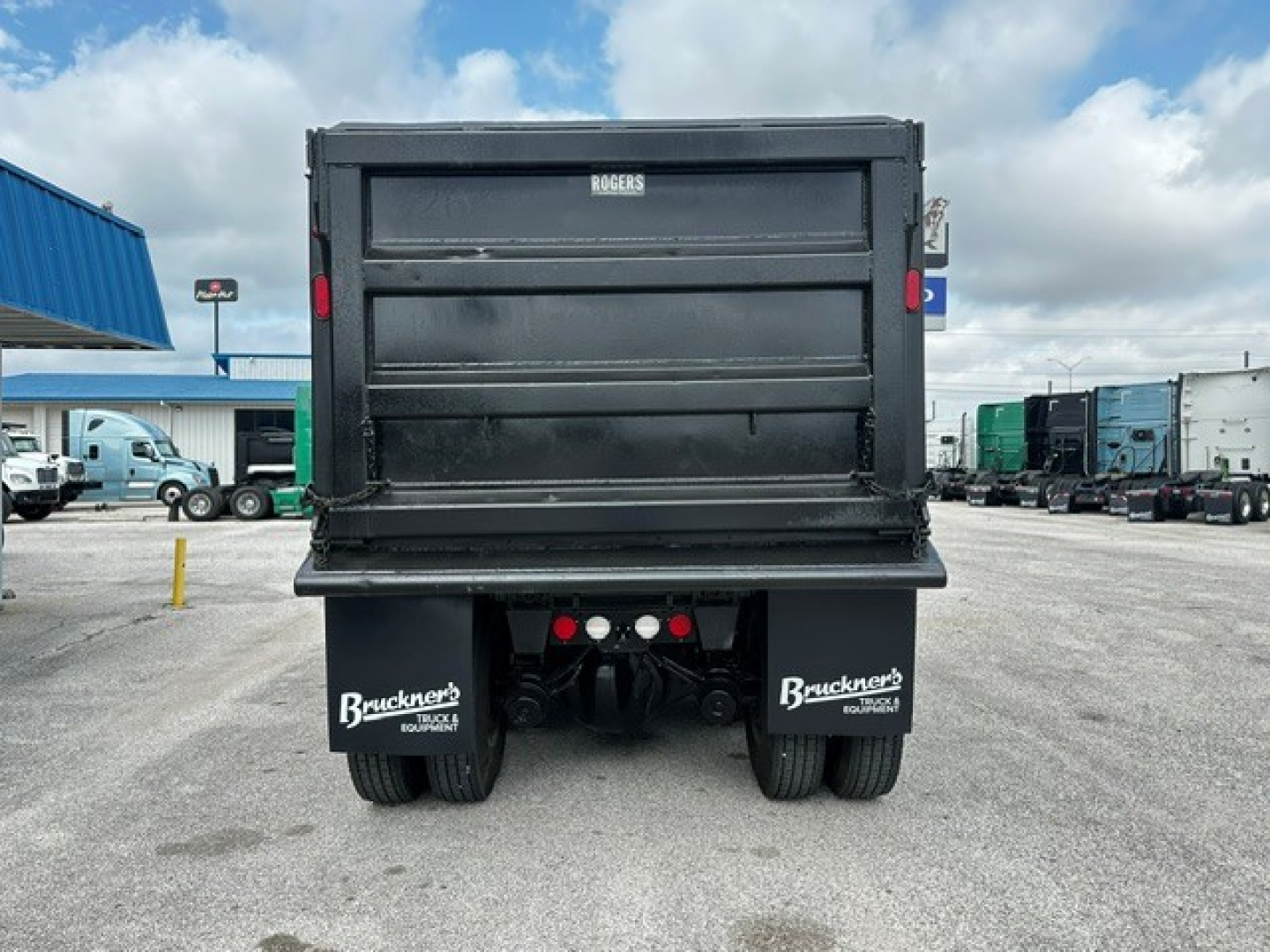 Rear view of a 2017 Kenworth T880 dump truck showing the truck bed tailgate and dual rear axles. Visible text includes 'ROGERS' on the tailgate and 'Bruckners' on the mudflaps.