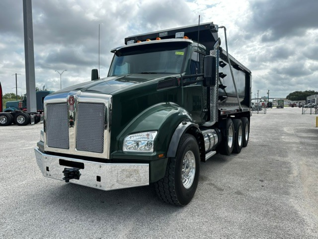 Kenworth T880 dump truck in dark green with chrome front bumper and grille, dual rear axles, 2017 model year, side view showing dump bed.