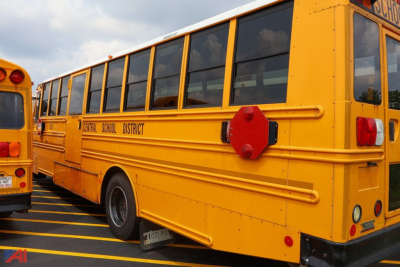 School bus side view showing yellow Freightliner Thomas Saf-T-Liner with 'Central School District' lettering and red rear lights.