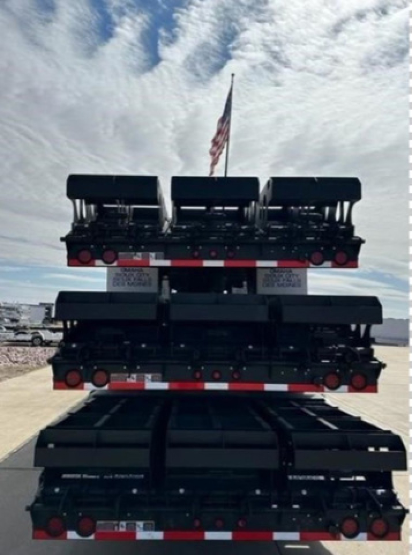 Dropdeck trailer stacked sections showing multiple axles and red/white reflective tape.