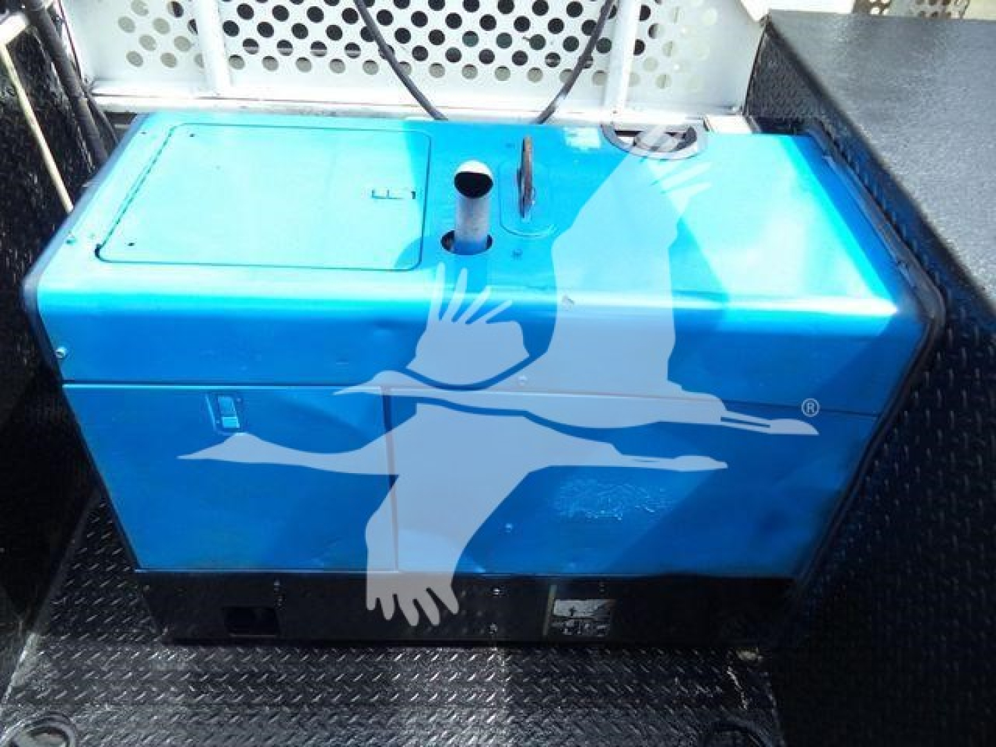 Blue fuel or storage tank with black base, mounted in truck bed; some piping protrudes from top; Kenworth service/utility truck context.