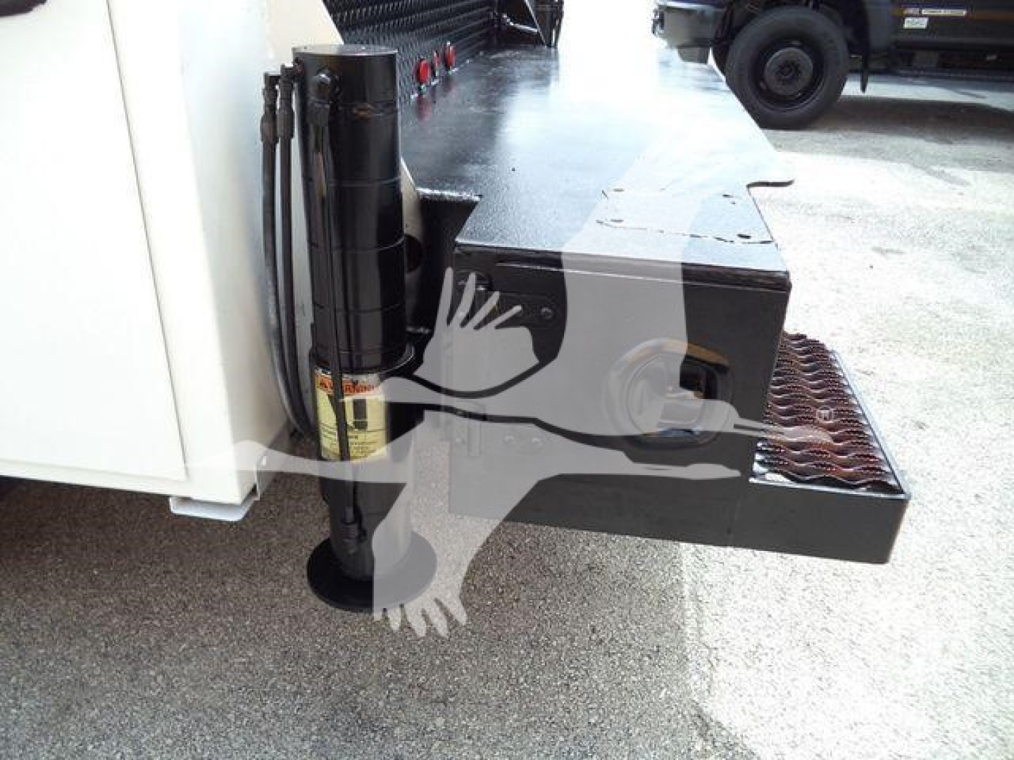 Kenworth T270 service truck rear step and hydraulic jack area with black metal platform and storage box visible.