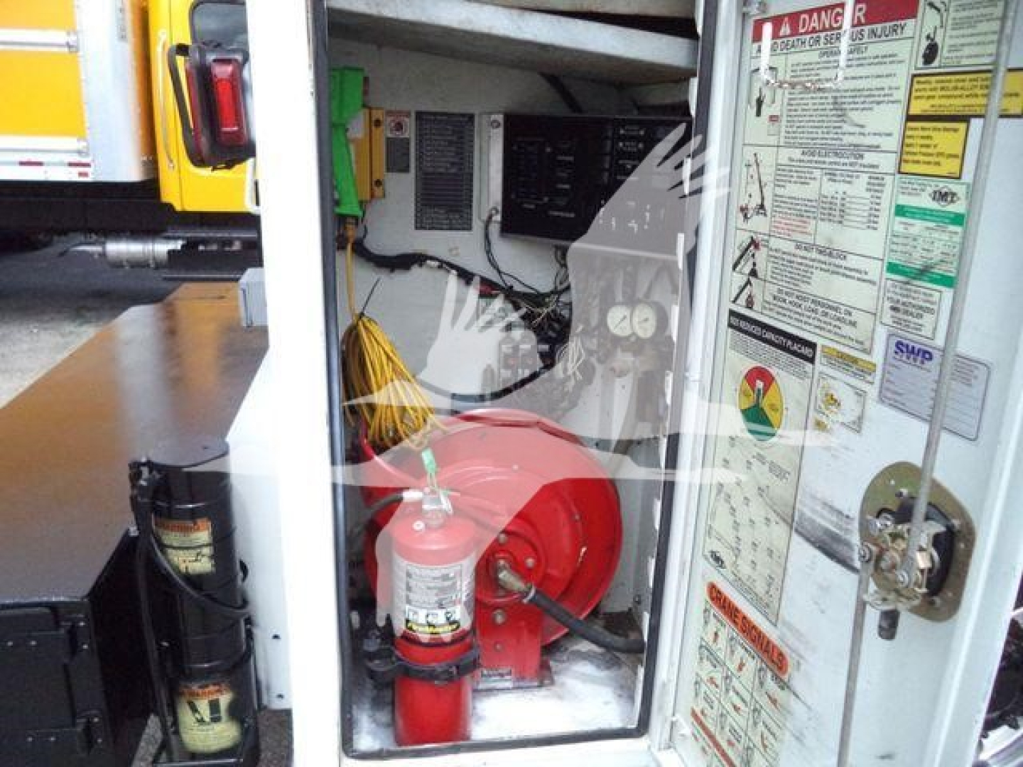 Kenworth T270 service truck compartment showing a red fire extinguisher and safety labels inside the cabinet.