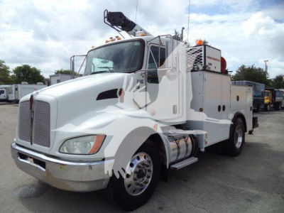 Kenworth utility truck with crane equipment showing service body and fuel tanks, front grille, headlights.