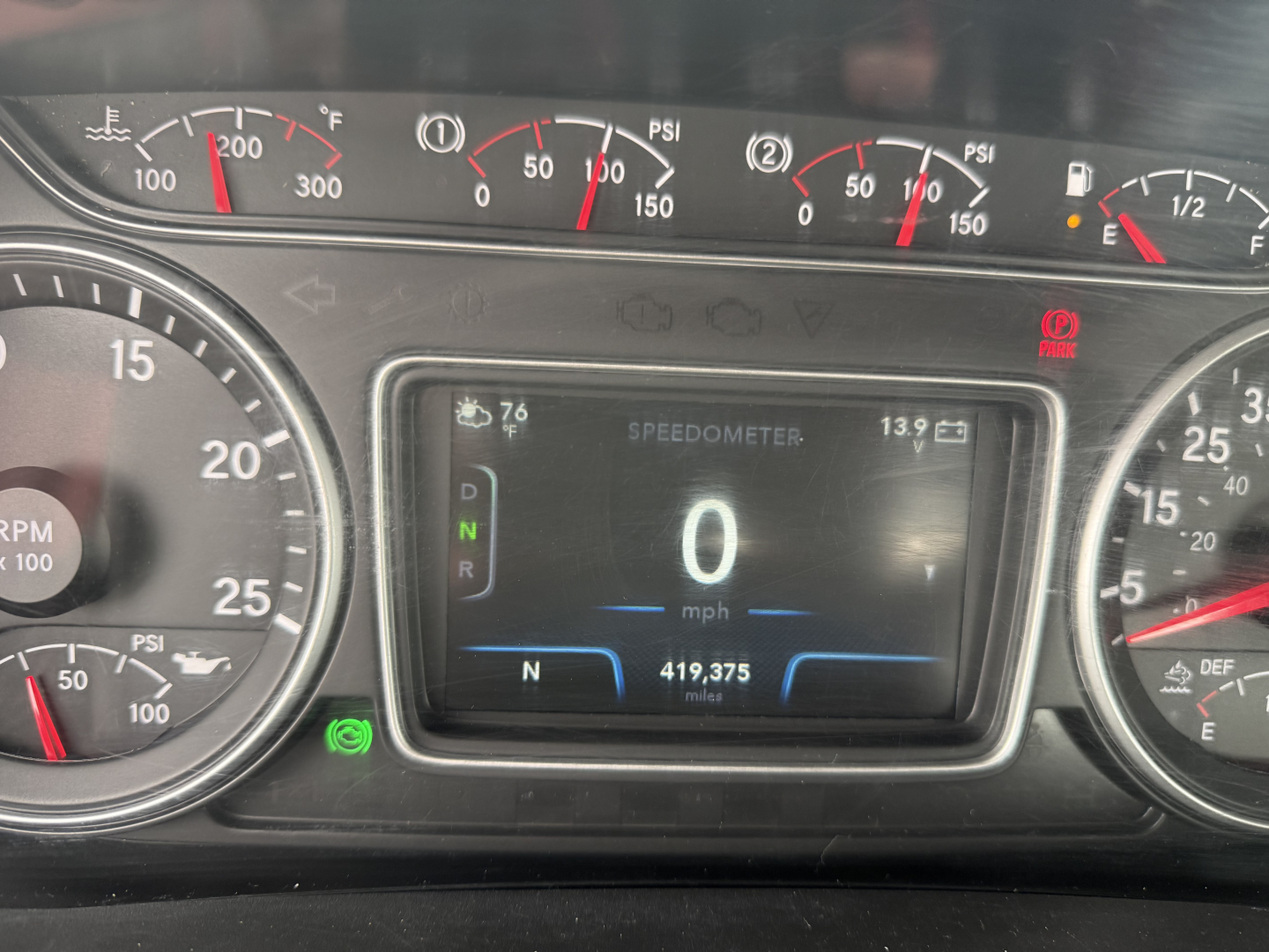 Dashboard view of a 2021 International LT625 cab: central digital speedometer shows 0 mph, gear indicators, odometer 419,375 miles, fuel gauges and multiple analog gauges around.