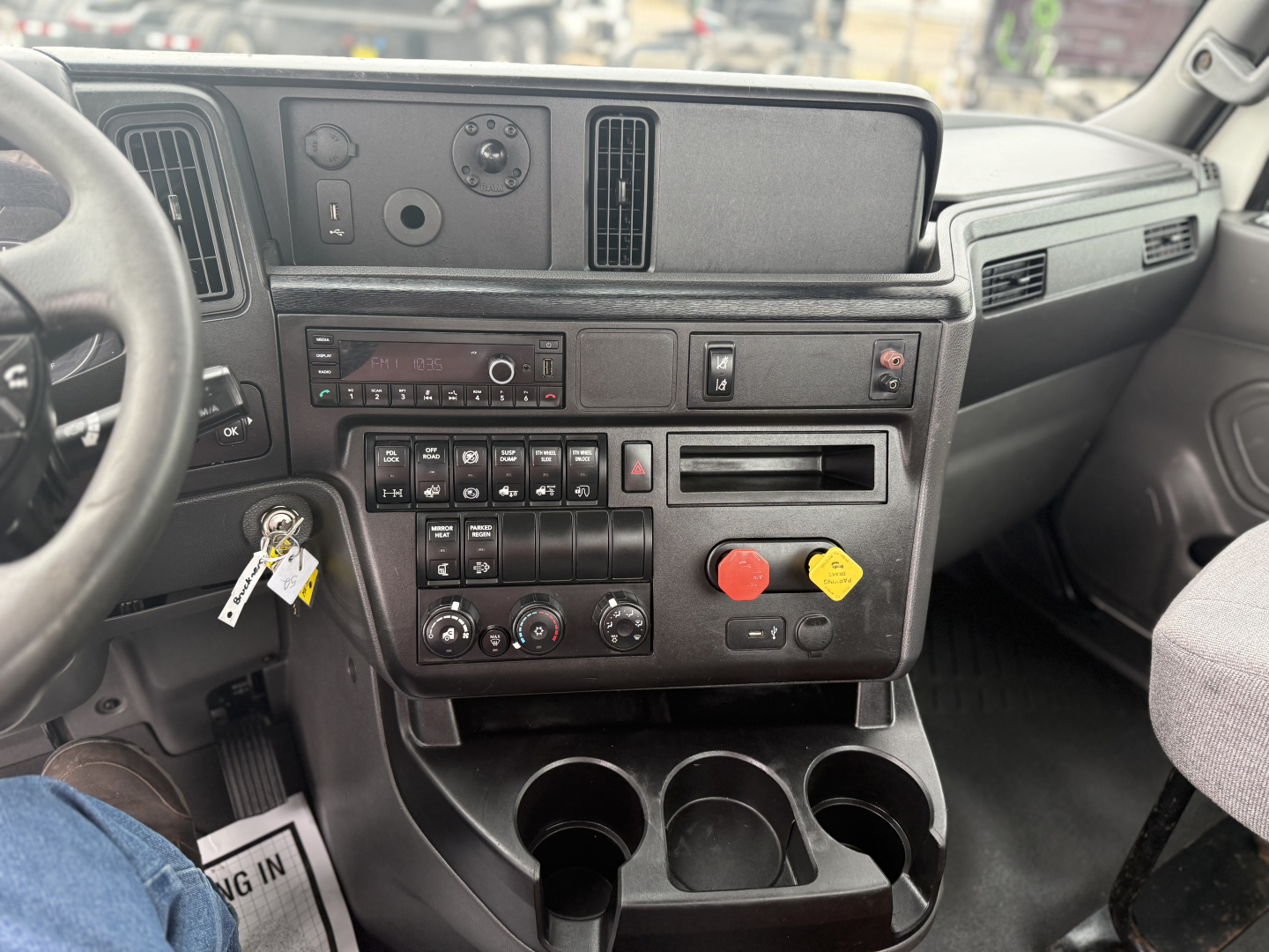 Dashboard center console of a 2021 International LT625 truck showing control panels, vents, and cup holders.