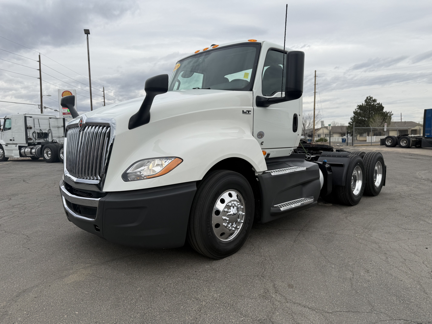 2021 International LT625 conventional daycab truck left-rear view showing cab, grille, dual rear axles, and large fuel tanks.