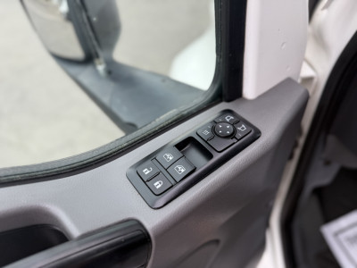 Door panel with window/lock controls of a truck cab showing mirror switch cluster and window controls.