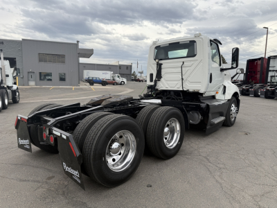 Truck chassis of a 2021 International LT625 daycab from rear three-quarter view showing dual rear axles and cab with white paint.