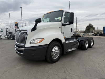 2021 International LT625 conventional daycab truck left-rear view showing cab, grille, dual rear axles, and large fuel tanks.