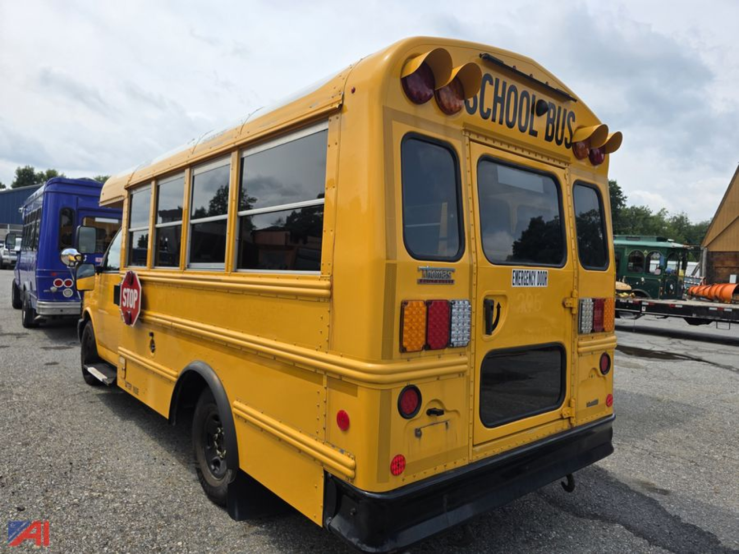Rear view of a yellow 2019 Chevrolet Express school bus, showing 'SCHOOL BUS' sign on top, rear doors, stop sign, and taillights.