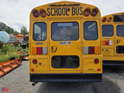 Rear view of a yellow school bus with 'SCHOOL BUS' lettering, Emergency Door label, and multiple taillights visible.