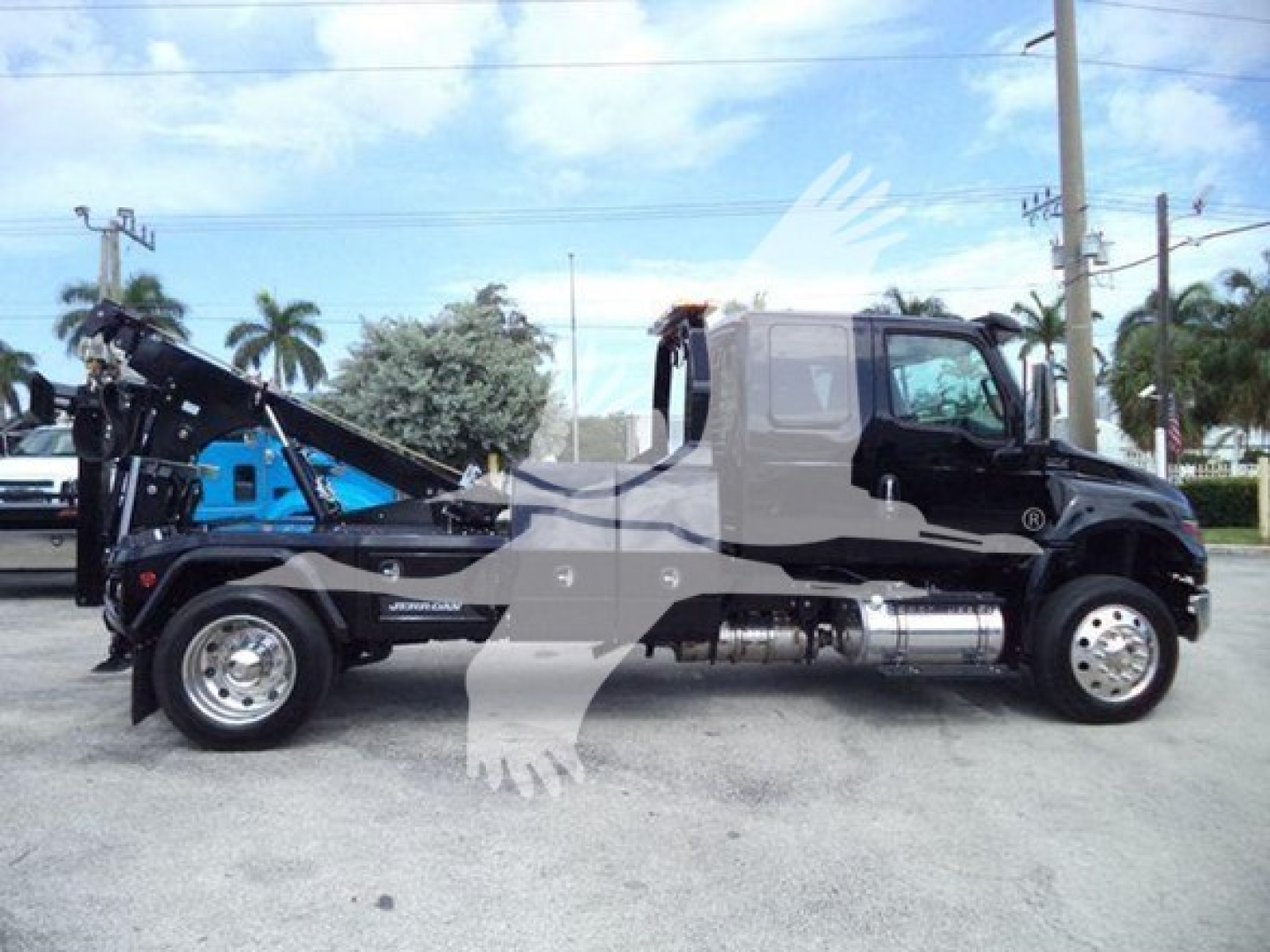 Truck side view showing 2025 International MV with a dump bed and winch equipment.