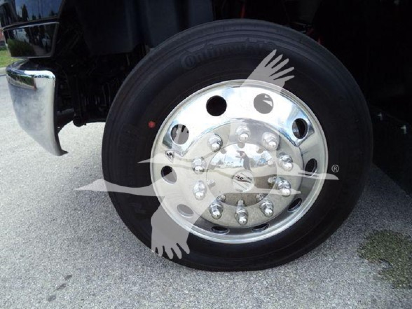 Truck wheel with chrome hubcap and black tire visible in wheel well.