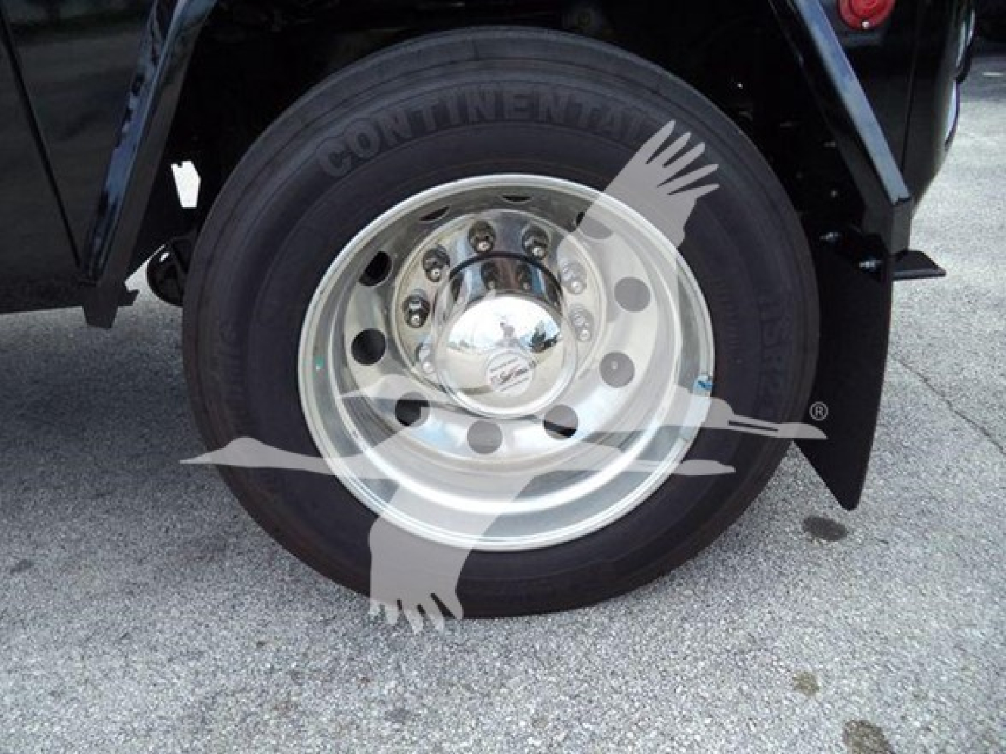 Truck wheel and tire assembly with Continental tire and polished steel rim mounted on a new International MV chassis.