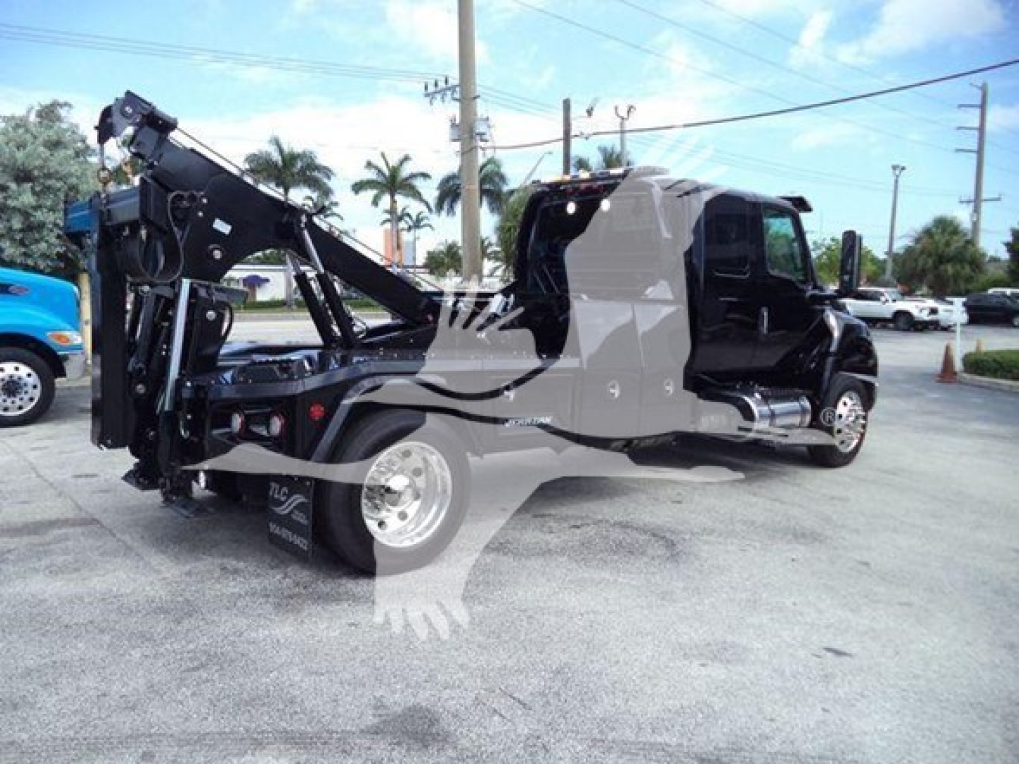 International MV tow truck with mounted winch system in the bed. Side view shows cab and crane/winch apparatus on rear, with visible label 'J-78070' on side.
