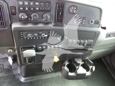 Truck interior dashboard showing controls, gauges, and cup holder area.