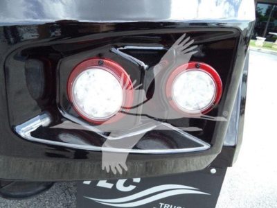 Truck front bumper with two round red-ringed headlights and a winch category badge on a glossy black surface.