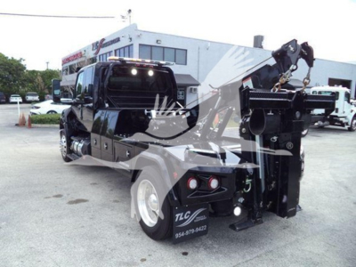 Tow truck chassis with crane arm and winch, rear view showing hydraulic boom and stabilizers, International MV front cab visible, stock number J78070.