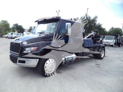 Truck cab and chassis showing International MV with chrome fuel tanks and winch equipment, side view including front grille and wheel.
