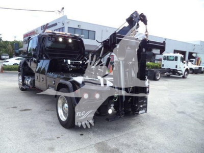 International MV truck with mounted hydraulic tow crane, rear view showing winch equipment and towing setup.
