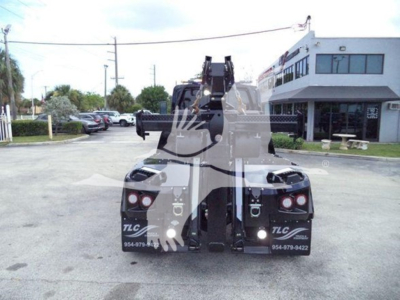 Tow truck with rear-mounted winch system and dual taillights, view from the back showing recovery equipment and branding TLC on the bumper.
