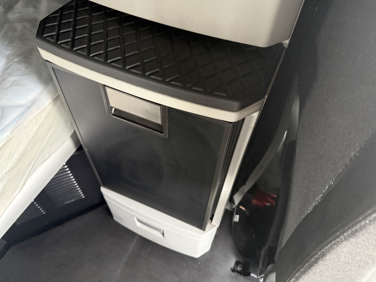 Kenworth T680 interior center console area with storage compartment and step tread visible.