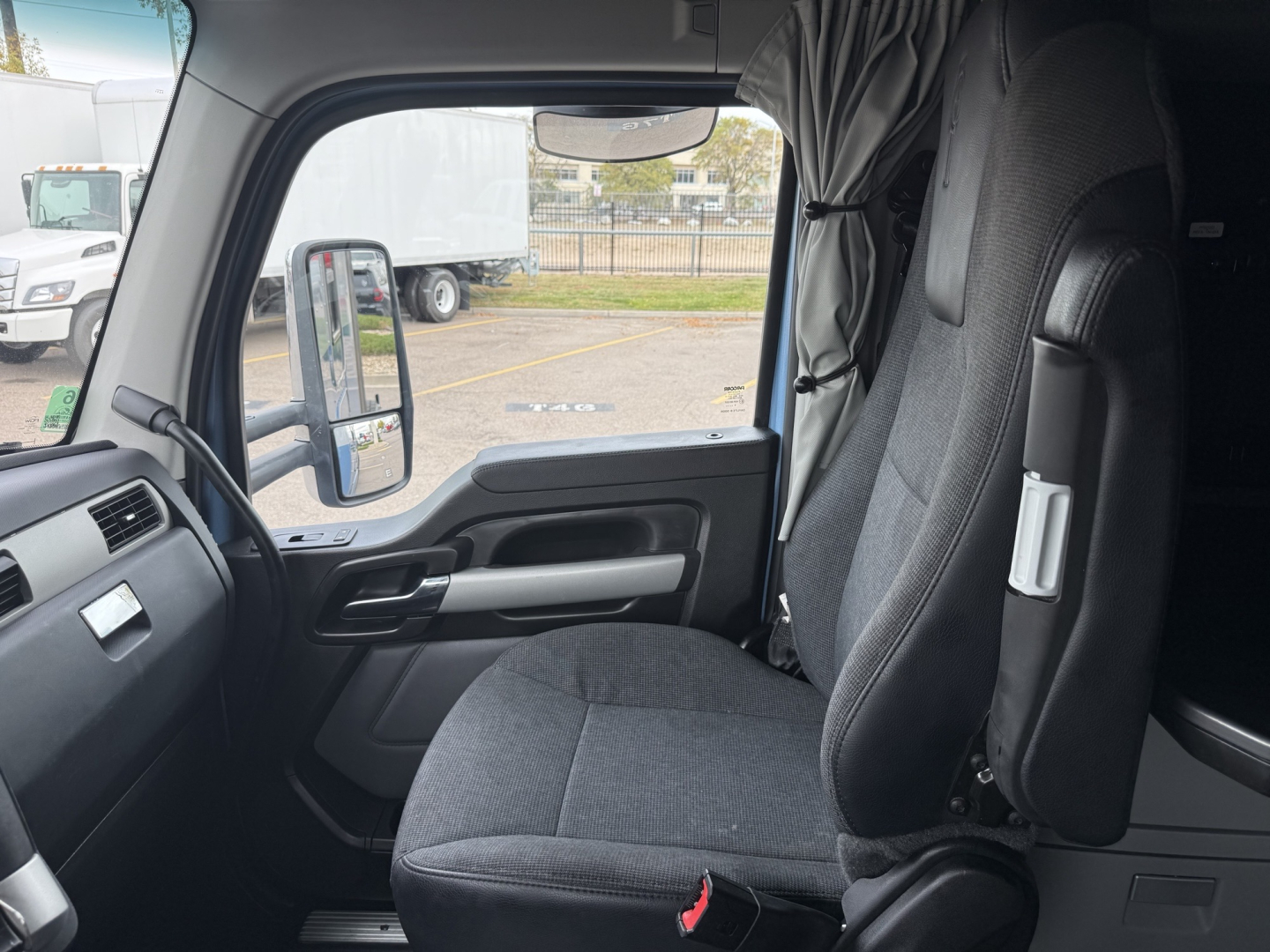 Kenworth T680 truck interior photo showing driver seat and door panel from the cab entrance.