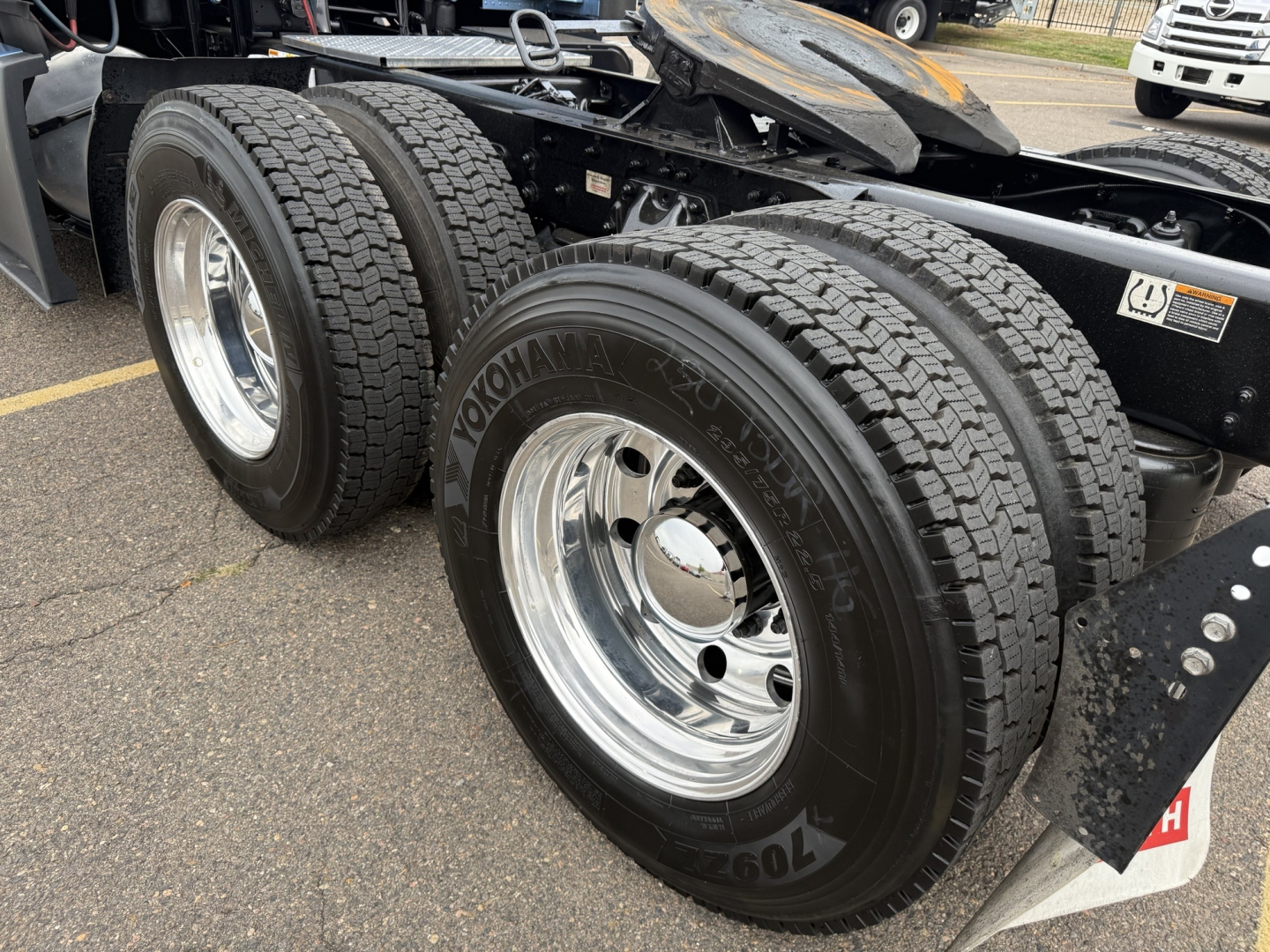 Kenworth T680 truck rear wheel assembly showing Yokohama tires and polished chrome rims in a used vehicle listing.